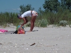 A couple of nudism lovers hardly pairing off on the sand