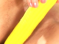 Provoking blonde slides a yellow dildo in and out of her aching pussy